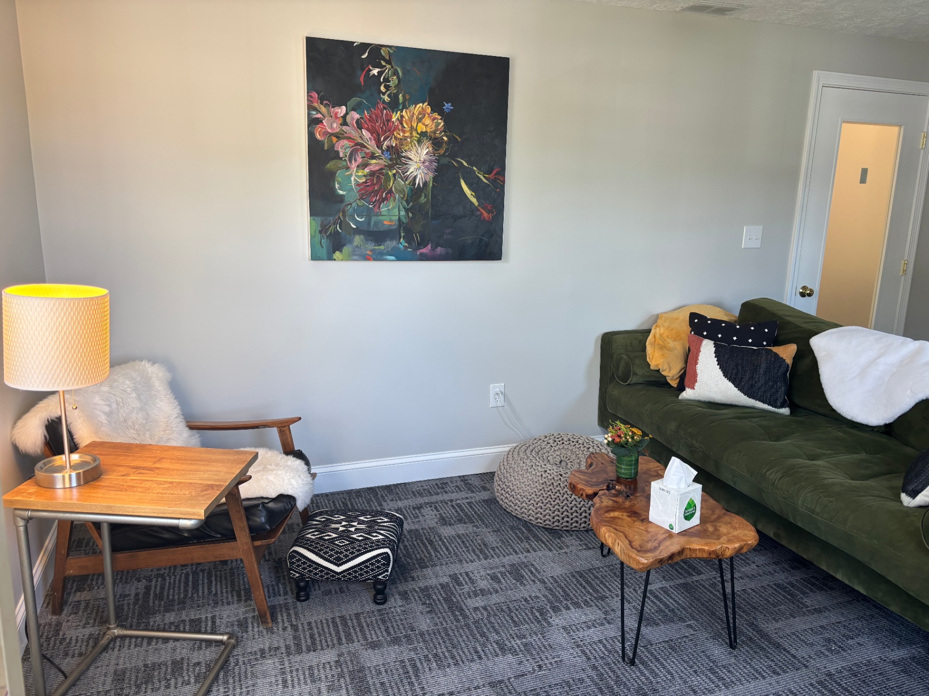 Reading chair, lamp, and floral artwork in the office