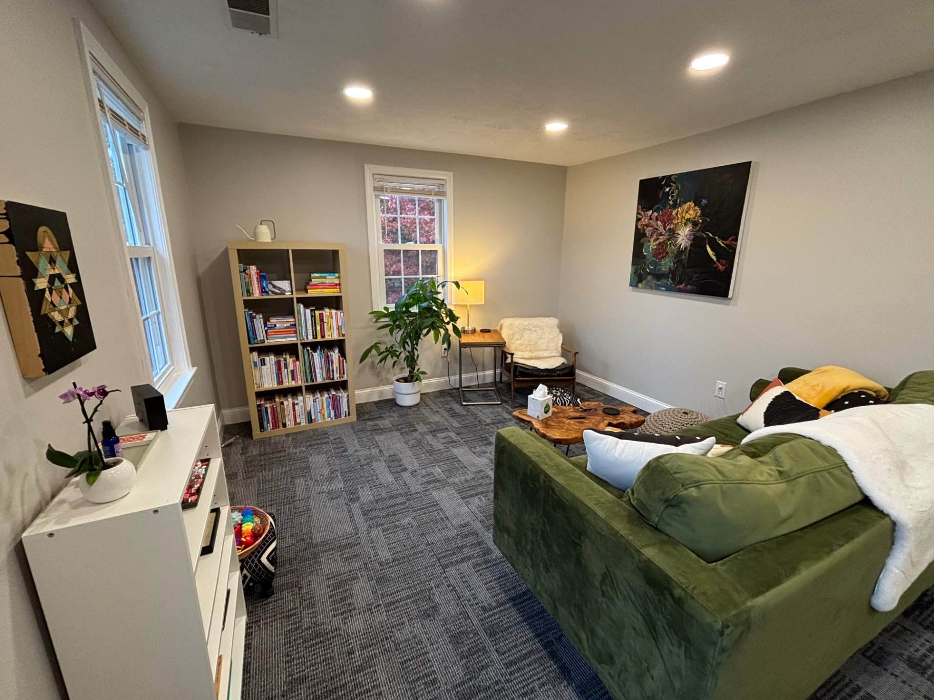 Office view with green sofa, bookshelf, and reading chair